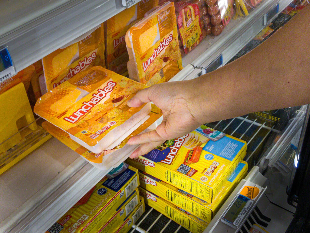 Shiloh, IL--July 10, 2021; hand of shopper reaching into refrigerator section of grocery store selecting two Oscar Meyer Lunchable packages, a Kraft-Heinz brand of food.
By Philip